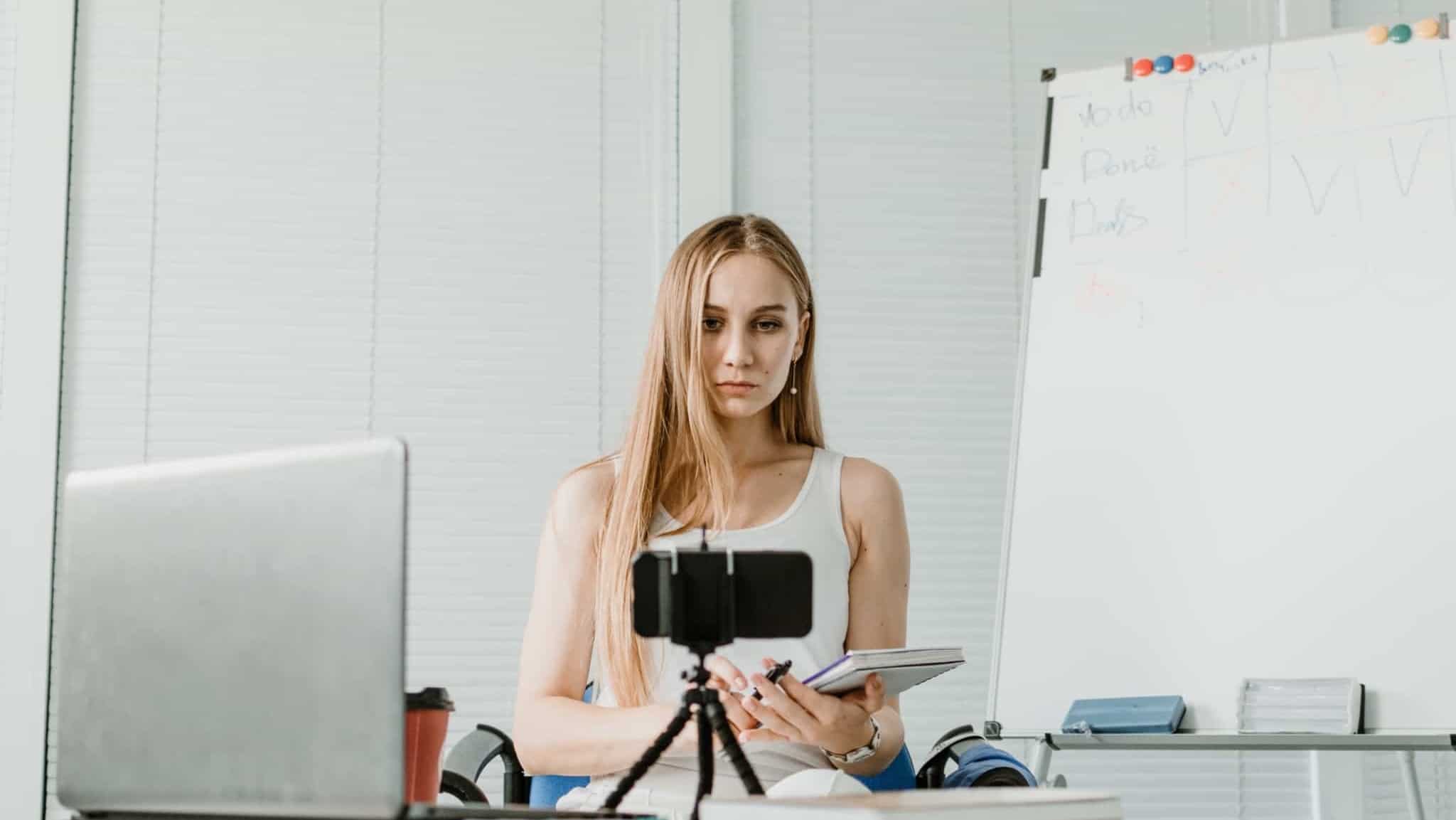 jovem mulher recorre ao telemóvel para produzir o seu trabalho extra