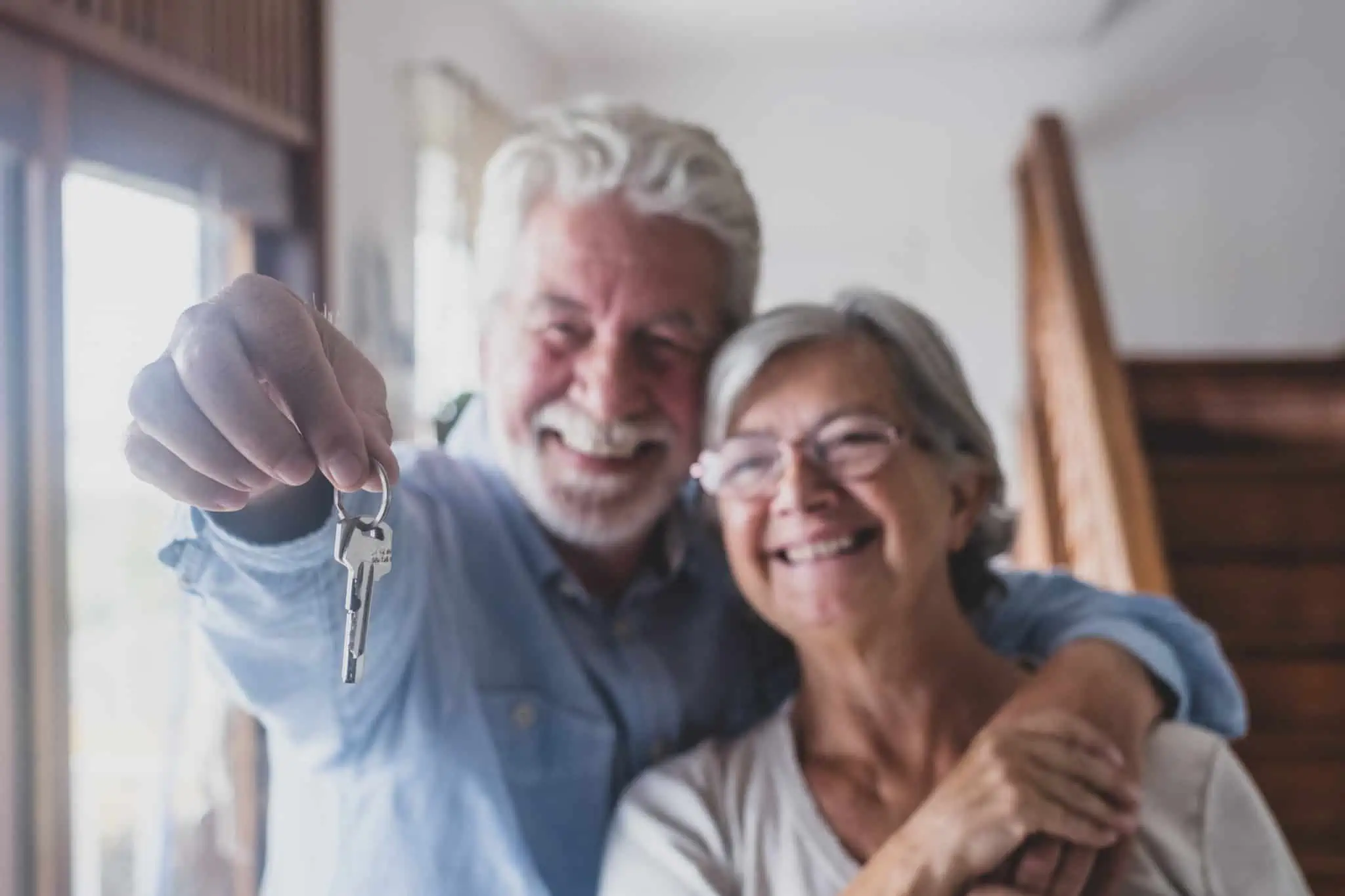 Até que idade posso contratar um crédito habitação? Casal em idade avançada a segurar chave depois de comprar casa com crédito habitação