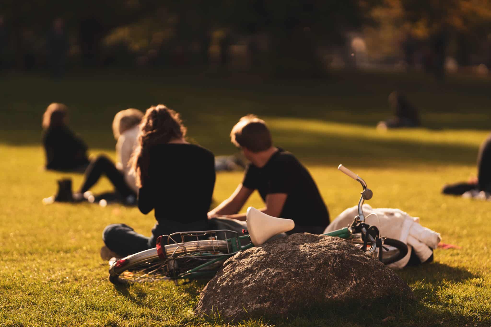 15 formas de ocupar o tempo livre sem gastar dinheiro alguns jivens espalhados pelo relvado de um jardim público, junto das suas bicicletas, a aproveitar as diversas formas de ocupar o tempo livre
