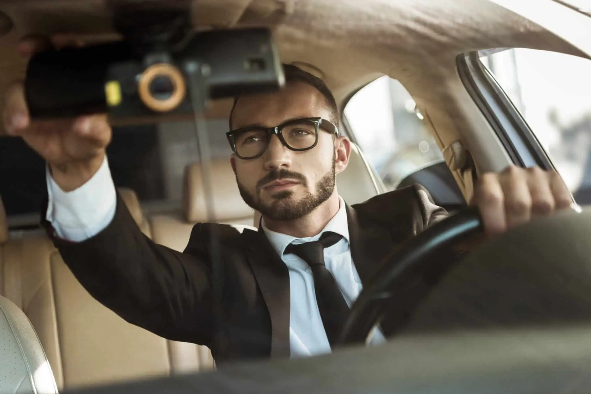 8 passos a cumprir para ser motorista TVDE jovem homem, motorista TVDE, ajusta o espelho do retrovisor do carro que conduz