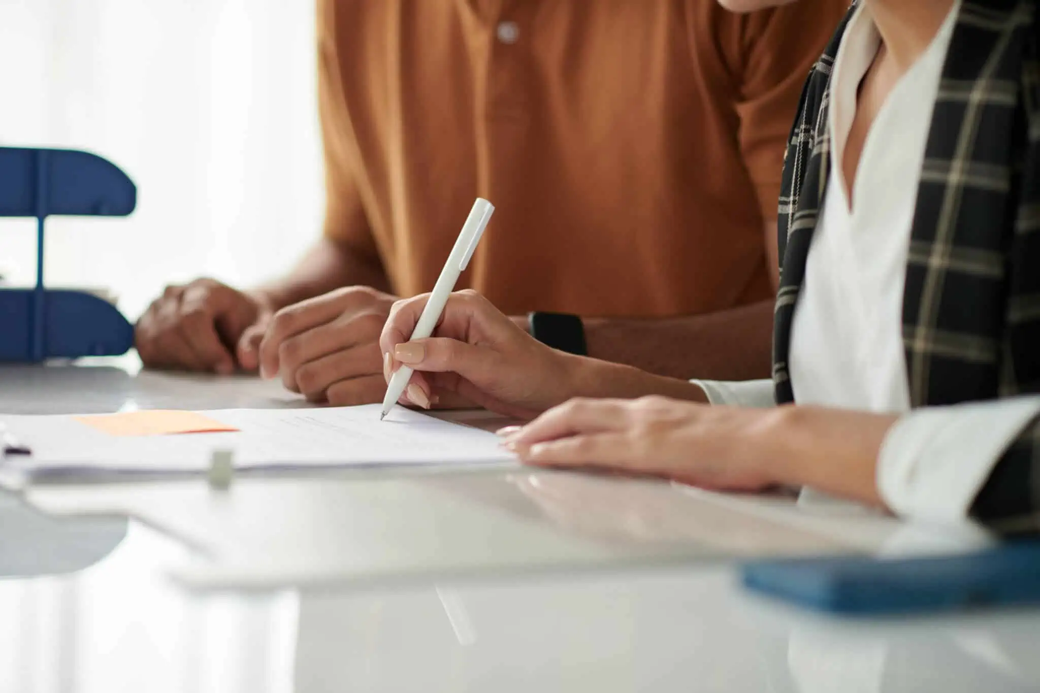 Que tipo de herdeiros existem e como se diferenciam? mãos de um homem e de uma mulher, jovens, herdeiros, assinam documentos assumindo a herança que receberam por falecimento de entre querido