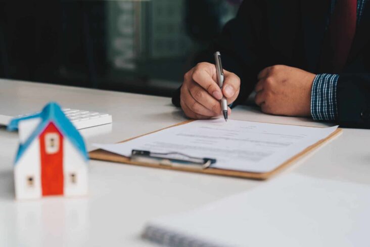 Pessoa a assinar depois de saber o que deve constar num contrato com uma imobiliária