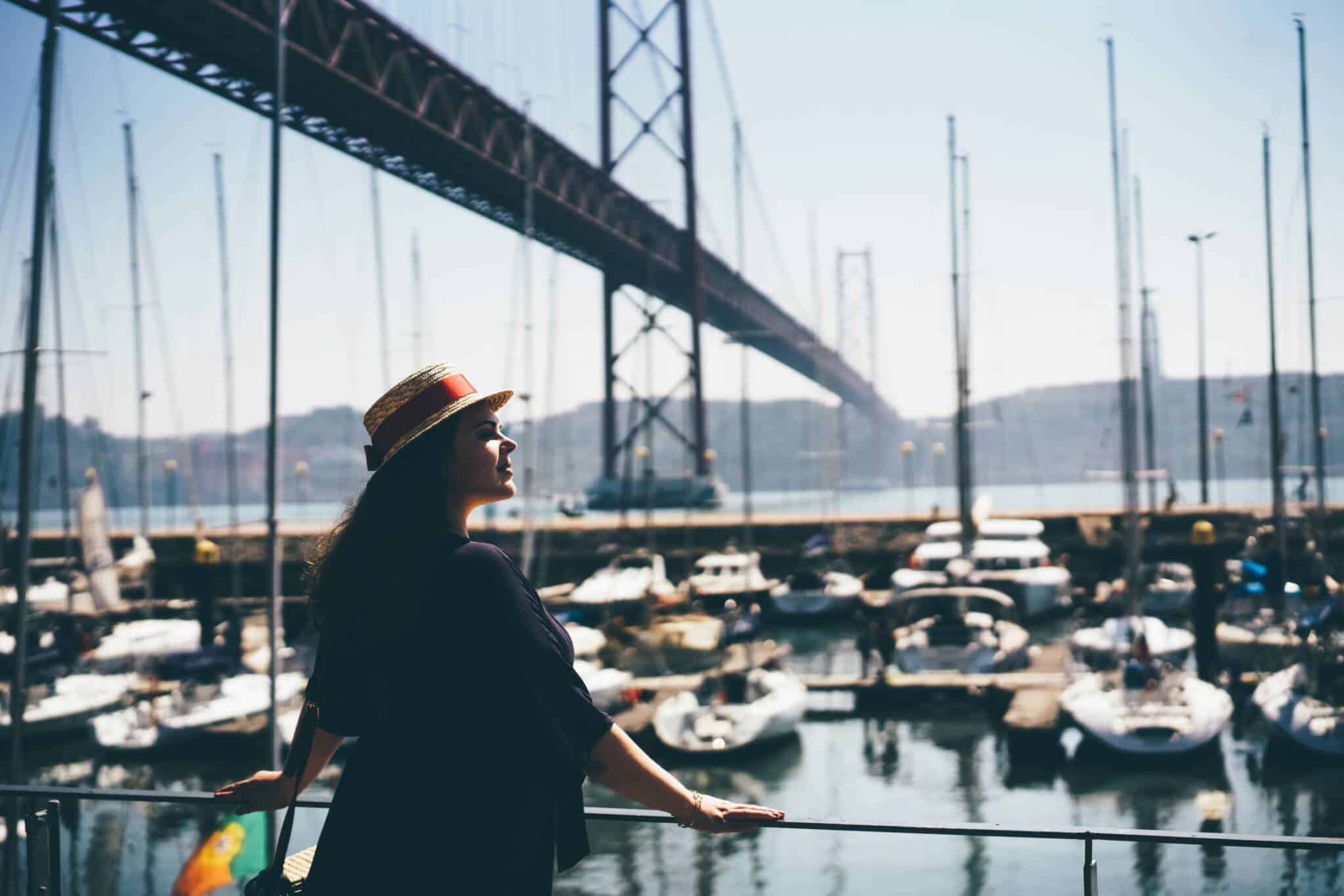 jovem mulher a passear junto à Ponte 25 de abril, em Lisboa, a aproveitar as sugestões gratuitas da cidade