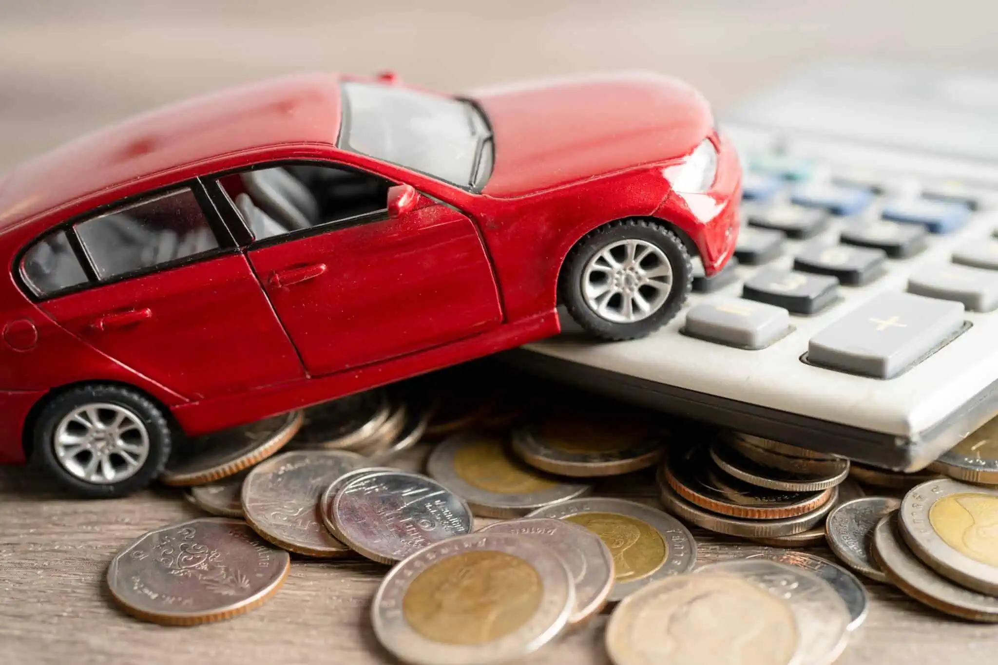 Compensa amortizar um crédito automóvel? carro em cima de uma calculadora e moedas a ilustrar se compensa amortizar um crédito automóvel
