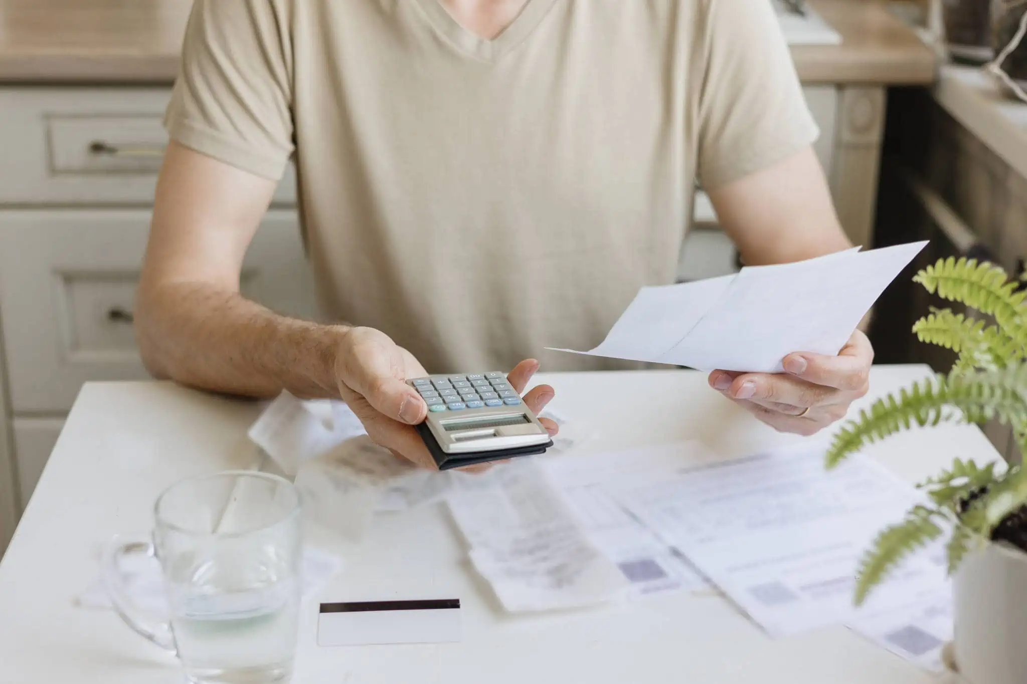 Homem com calculadora a pagar as contas