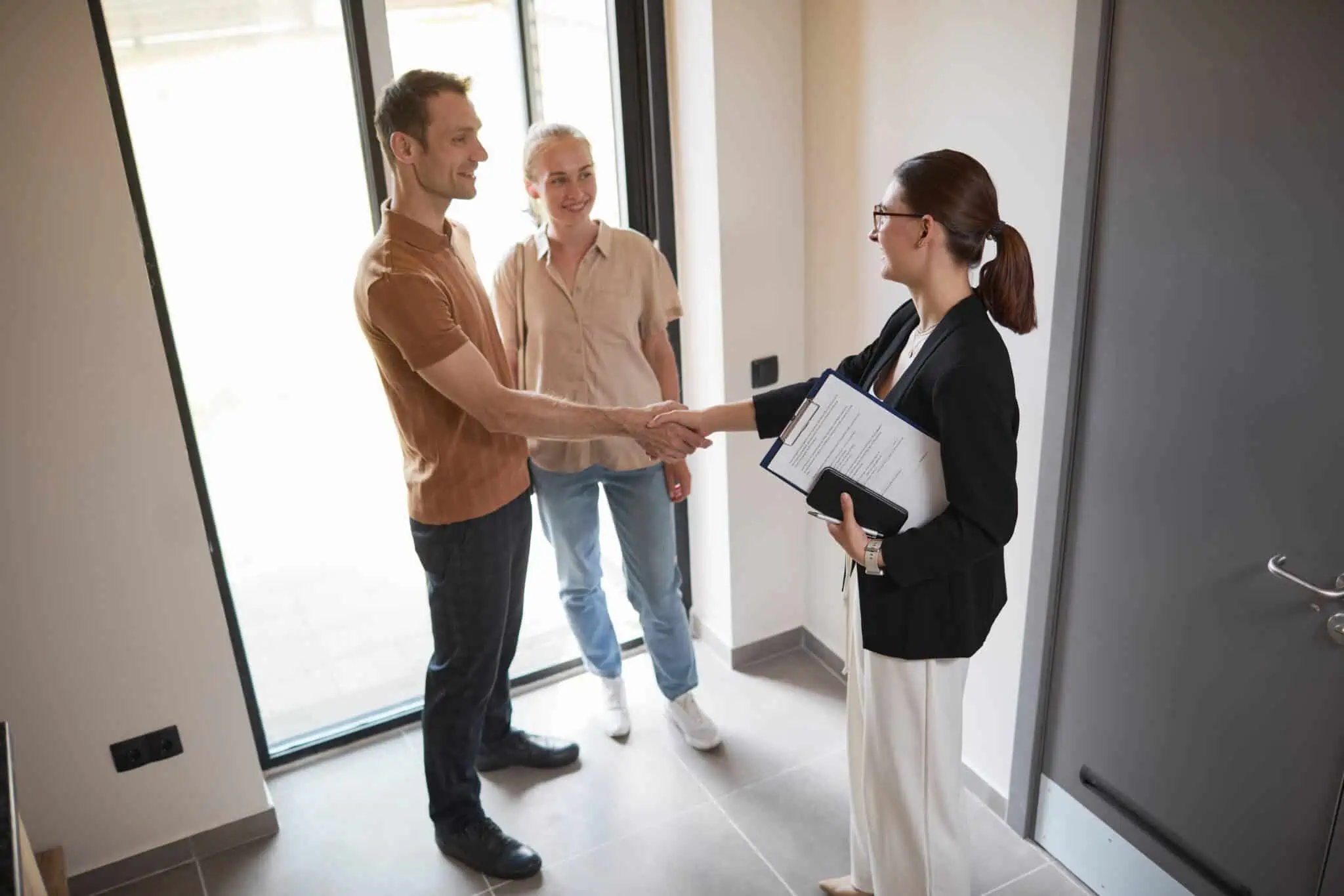 Comprar casas penhoradas: Saiba onde procurar, as vantagens e os mitos agente imobiliário a cumprimentar casal