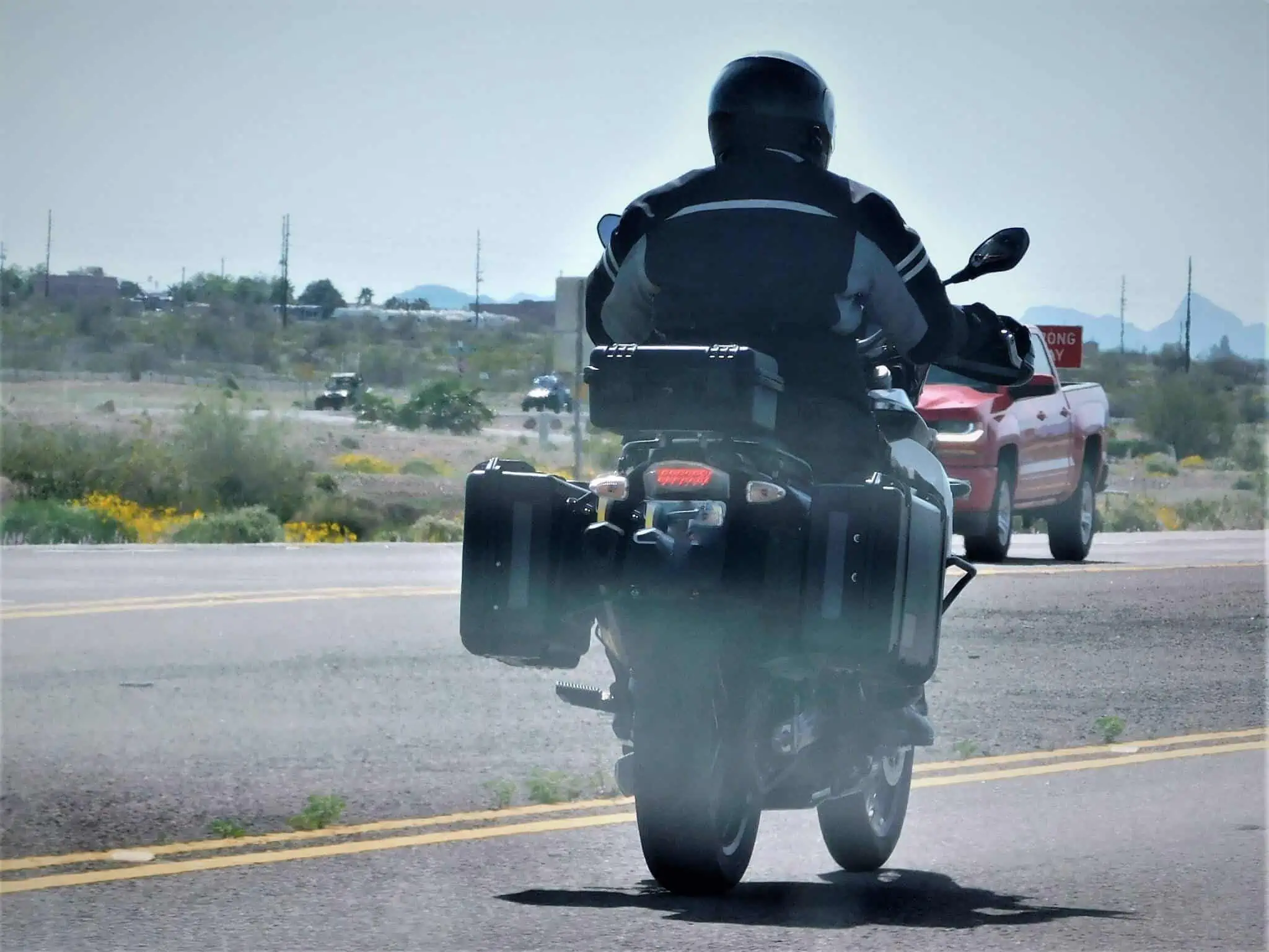 Seguro para motociclos: Quais as coberturas a considerar? jovem rapaz de moto , com seguro para motociclos, a andar na estrada de asfalto