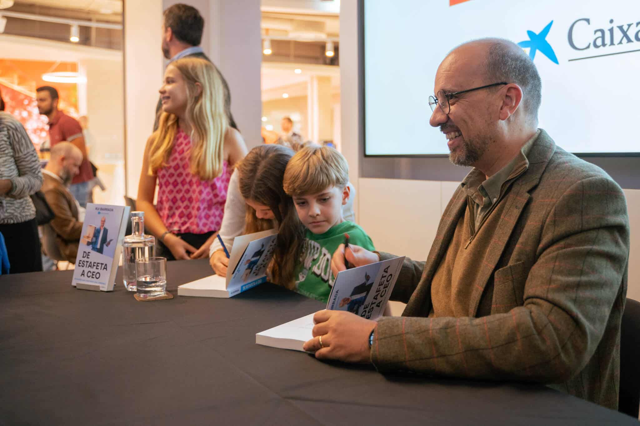 Rui Bairrada a autografar o livro De estafeta a CEO rodeado pelos três filhos