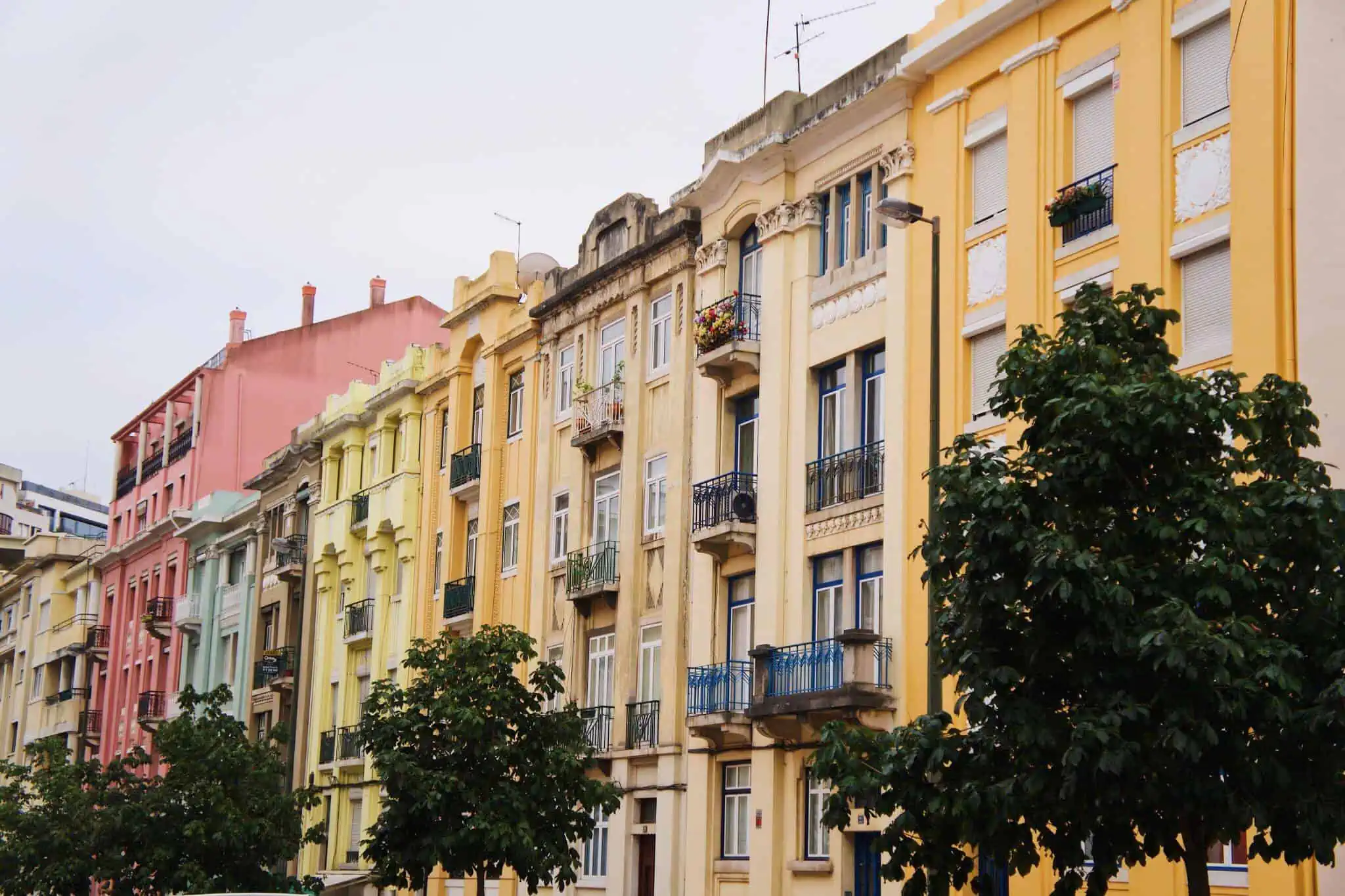 Mais Habitação: O que muda no IMI? prédios de várias cores e árvores â frente