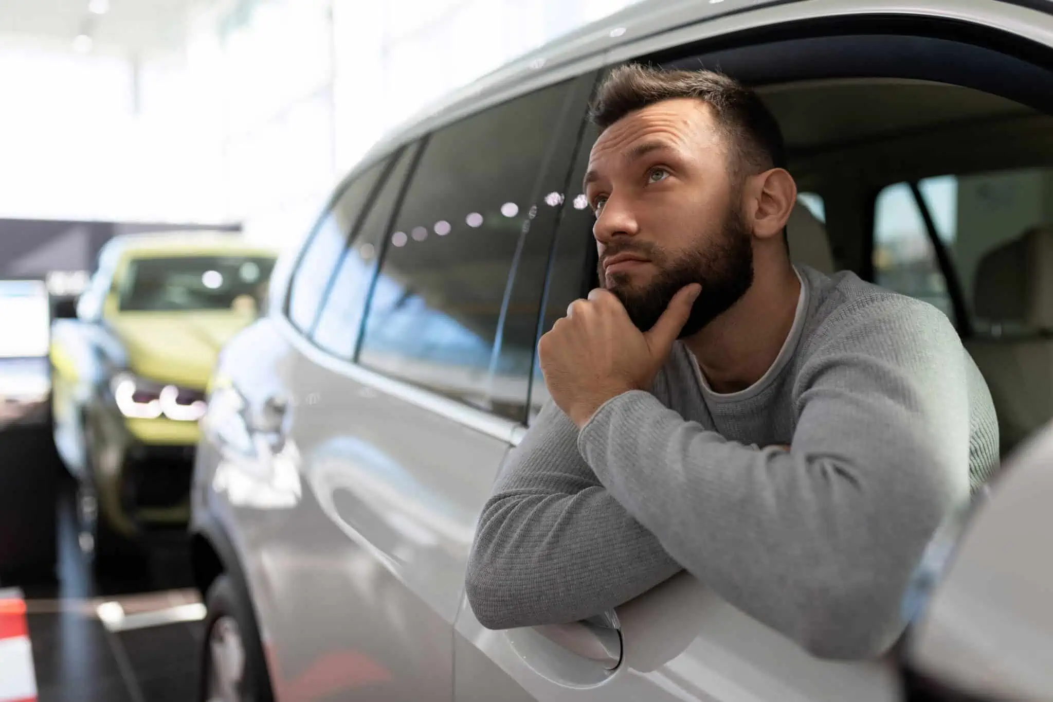 Homem indeciso se compra carro com crédito pessoal ou crédito automóvel