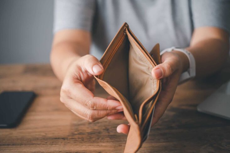 homem a mostrar carteira vazia