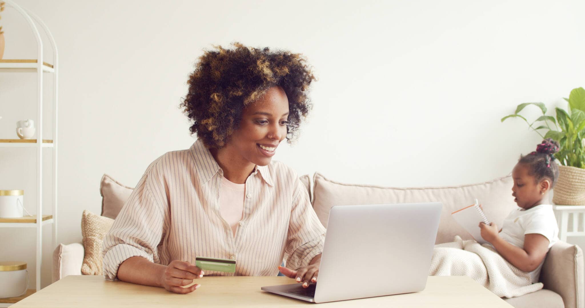 Mulher feliz porque está ao computador a poupar nos seus créditos