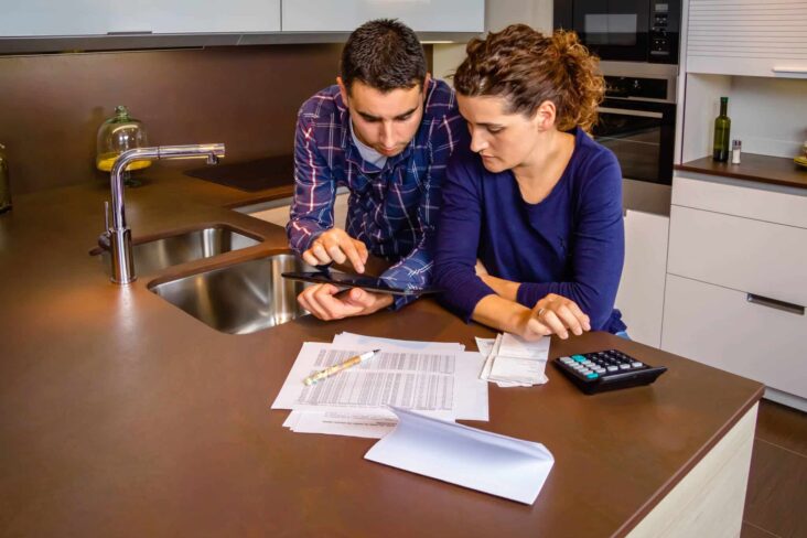 casal a rever a gestão do orçamento partilhado na cozinha e a fazer novos cálculos
