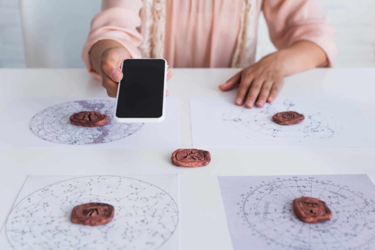mulher a consultar oráculo com telemóvel na mão