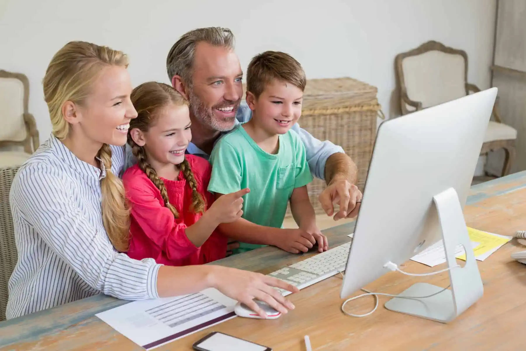 IRS: Dois titulares ou um titular de rendimento? casal com os dois filhos frente ao computador a atualizar o agregado familiar no portal das finanças