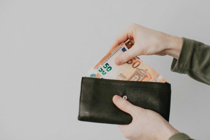 homem a tirar notas de uma carteira