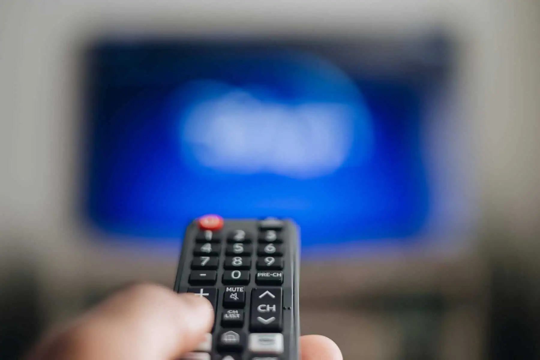 pessoa a segurar em comando de televisão
