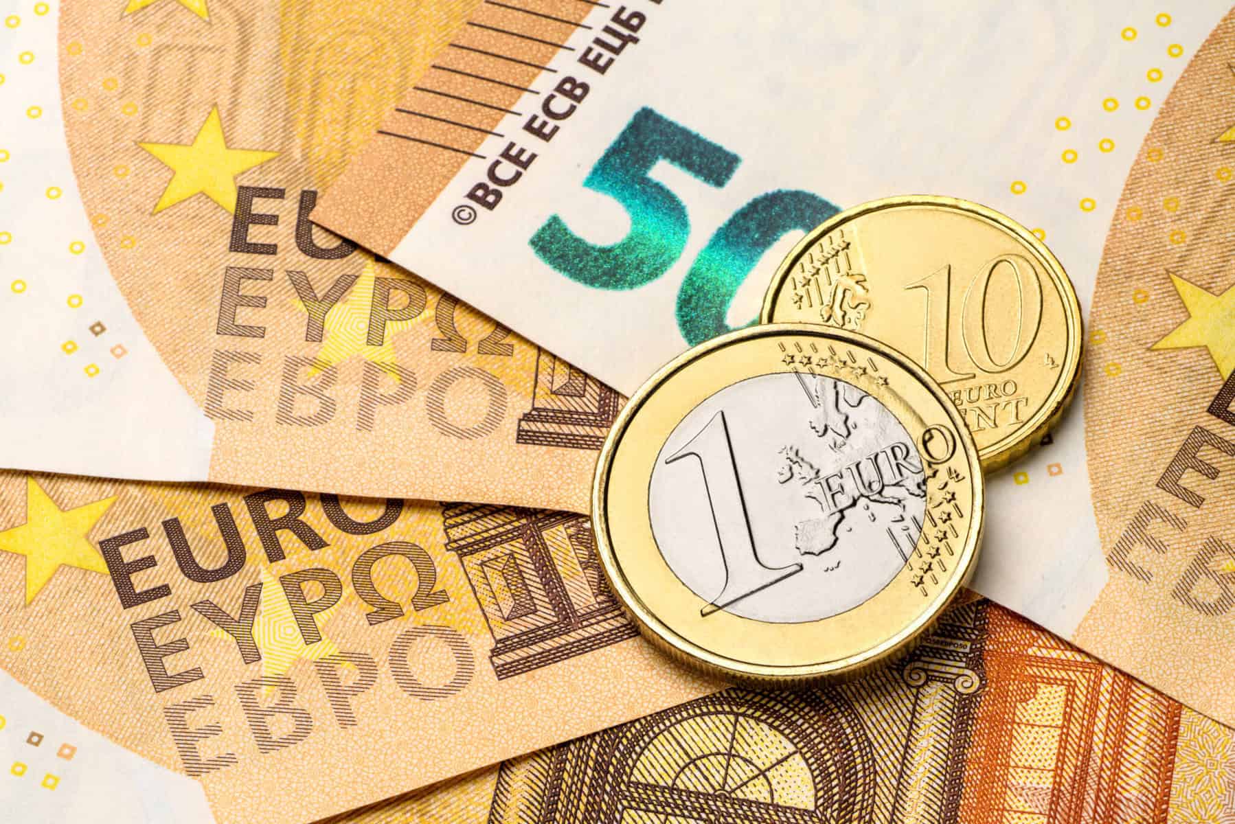 Juros no crédito ao consumo atingem novos máximos Uma moeda de um euro e outra de 20 cêntimos em cima de notas de 50 euros