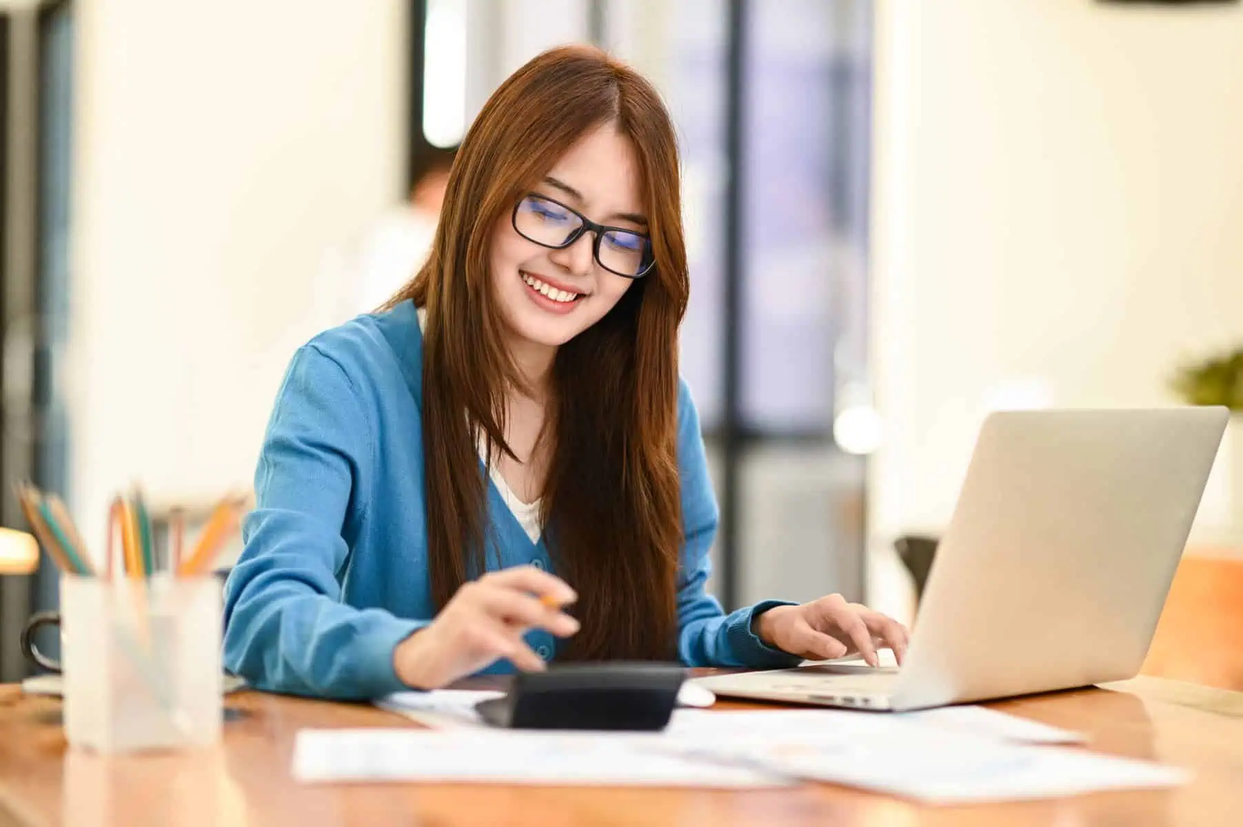 Renegociar um crédito pessoal: Que condições posso alterar? mulher a fazer contas na calculadora para conseguir renegociar um crédito pessoal