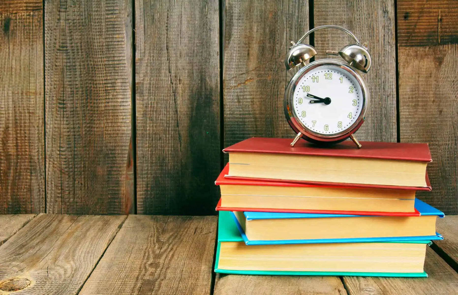 livros com um relógio por cima, a ilustrar quando é que tem de devolver os manuais escolares à escola