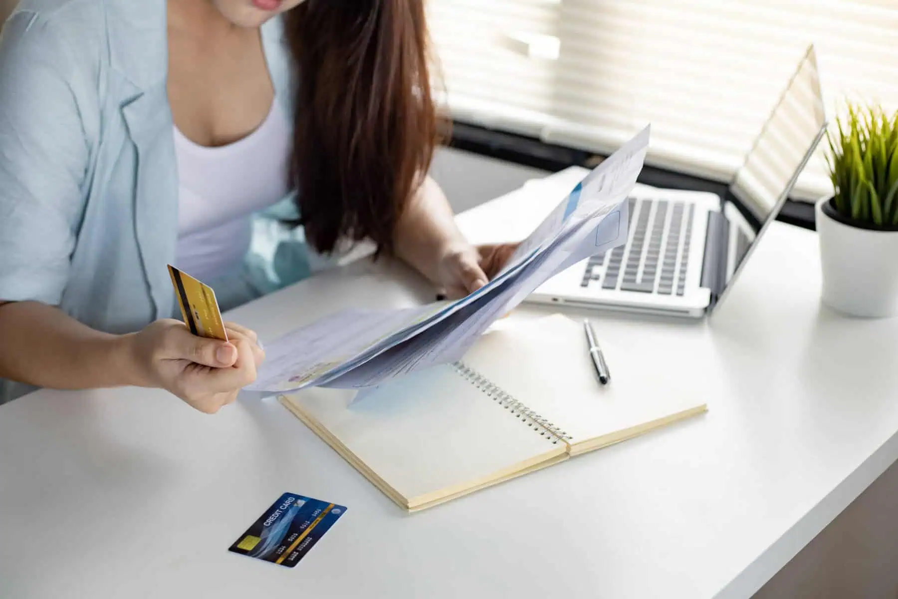 Como saber se as minhas dívidas de crédito estão liquidadas? mulher a analisar os seus contratos de crédito, após fazer um check up às suas finanças pessoais