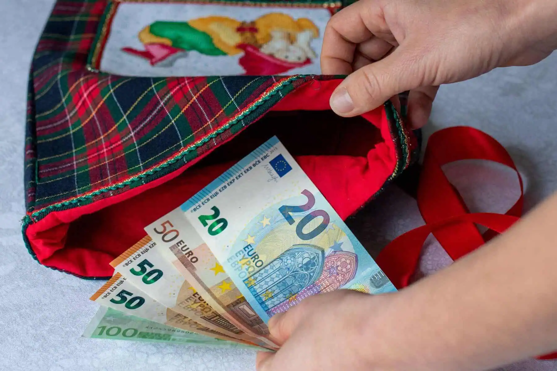 Subsídio de Natal no ano de admissão: Quanto se recebe? notas de euro e saco de Natal a ilustrar artigo sobre subsídio de Natal no ano de admissão
