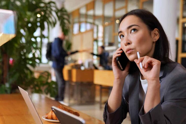 Mulher ao telefone com ar pensativo