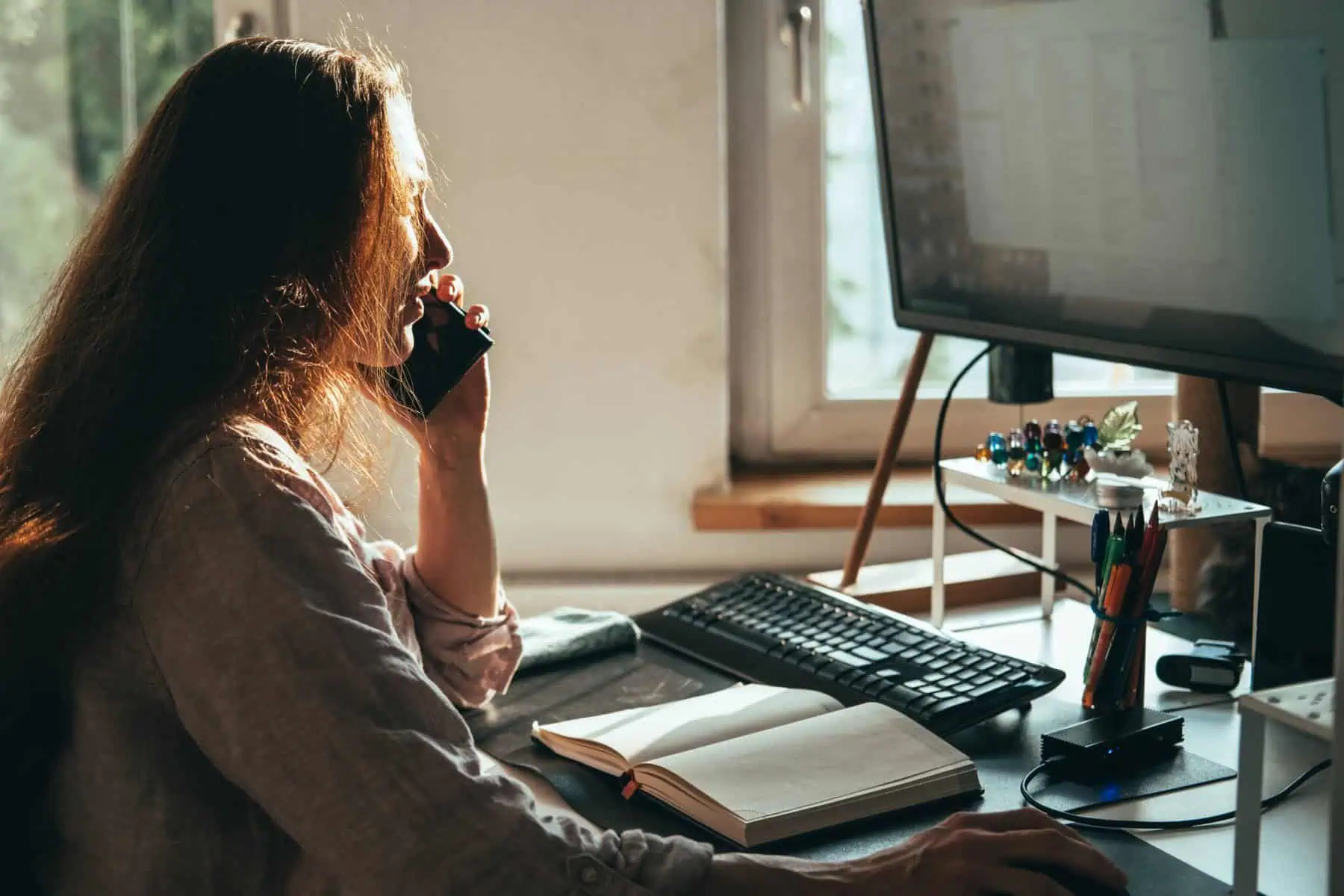 CAE: O que são e como escolher empresária em nome individual a esclarecer dúvidas sobre o seu CAE principal ao telefone frente a um computador