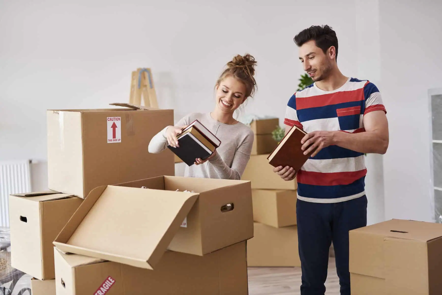 Garantia pública no crédito habitação para jovens: Perguntas e respostas Jovem casal retira livros dentro das caixas de mudança de casa, depois de terem comprado a sua primeira casa com a ajuda da garantia pública