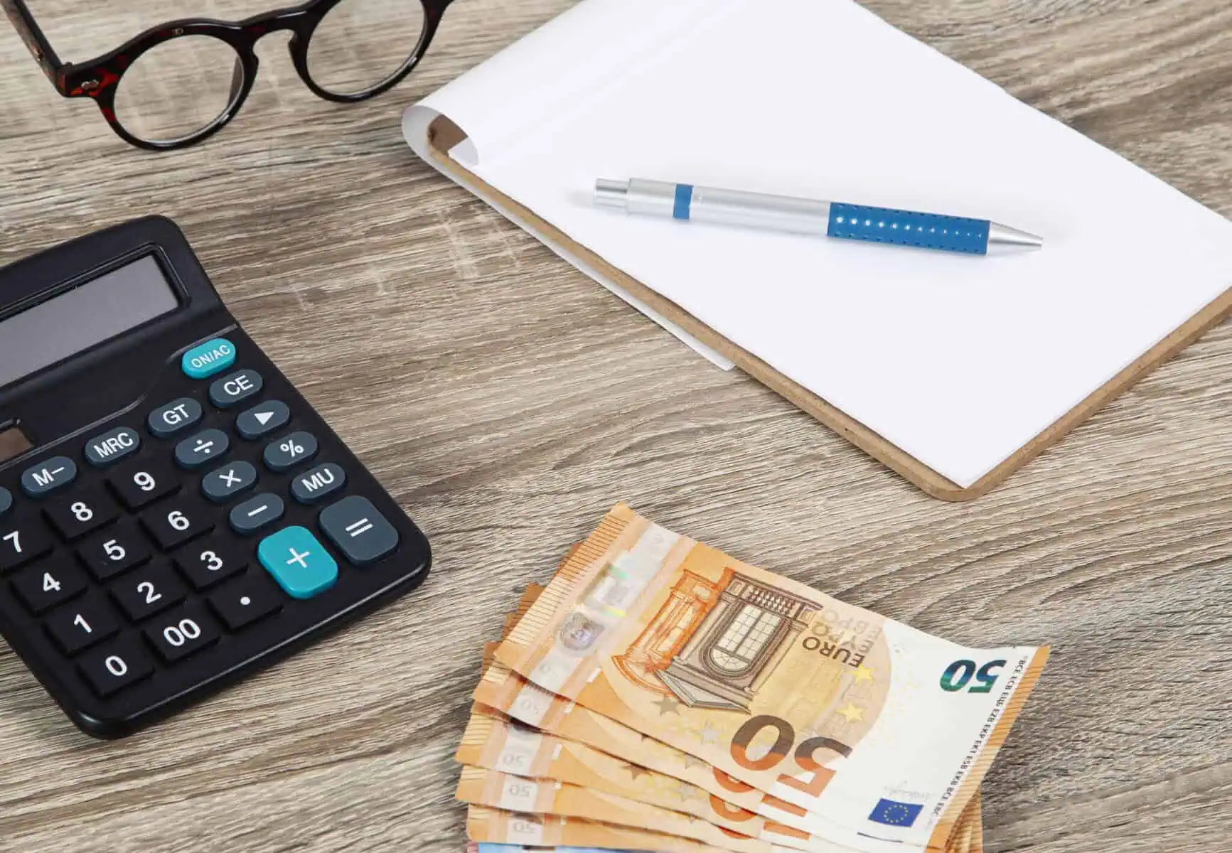 Crédito pessoal: O que ter em conta e os cuidados a ter calculadora, notas e bloco com uma caneta a ilustrar a importância que os cálculos e a informação pode ter antes de contratar um crédito pessoal
