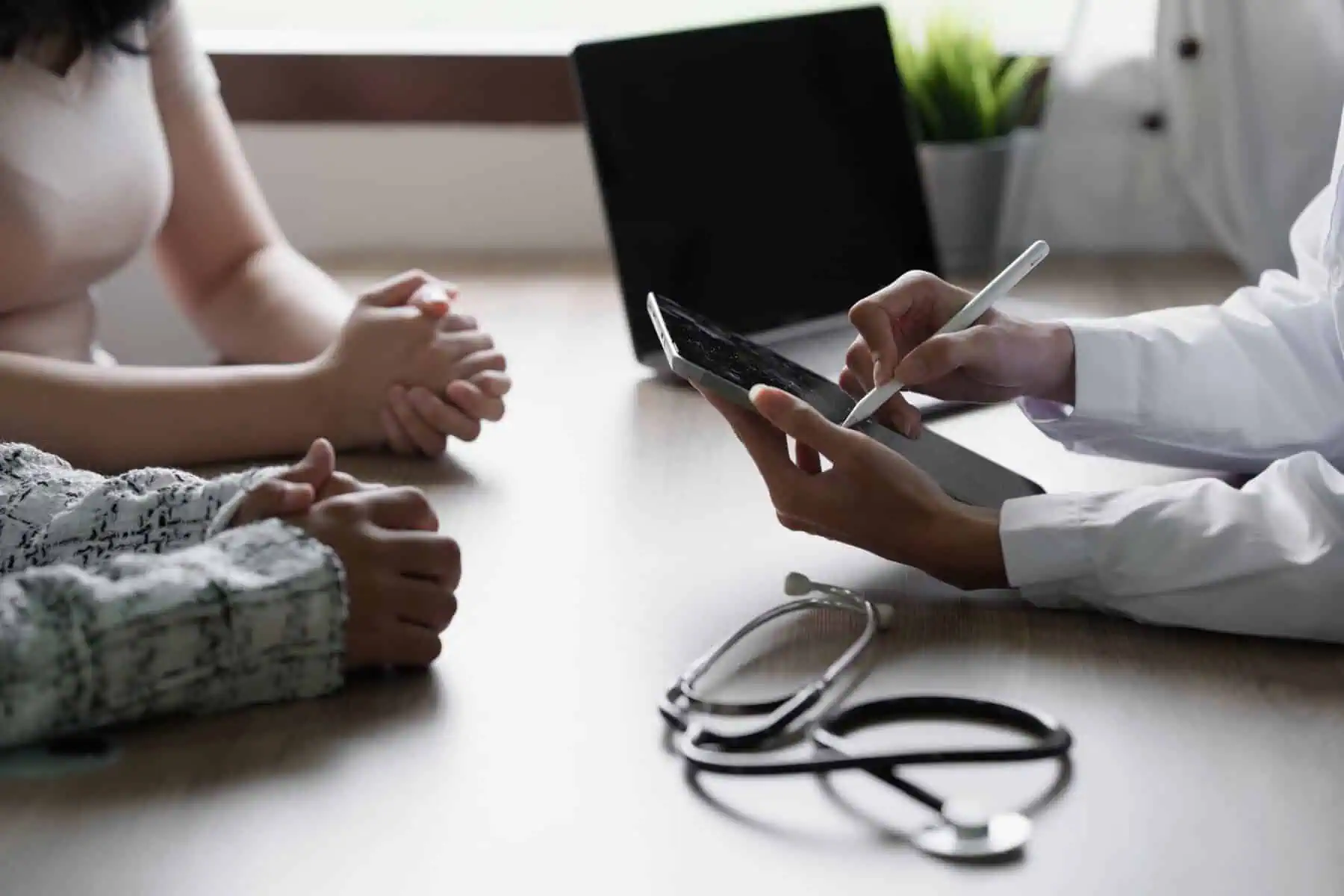 Seguro de vida ou para doenças graves: Qual a diferença? Consulta médica, em que um médico apresenta o resultado de exames aos pacientes.