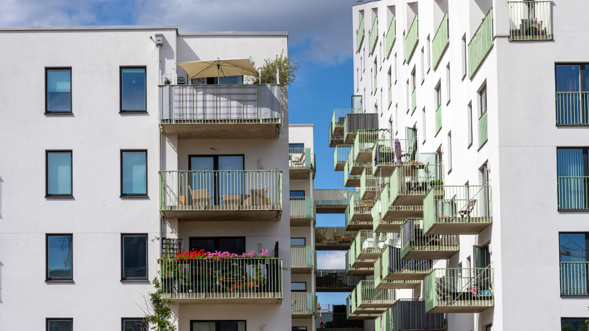 Habitação a custos controlados: O que é e quais os preços? Prédios brancos com belas varandas ao sol