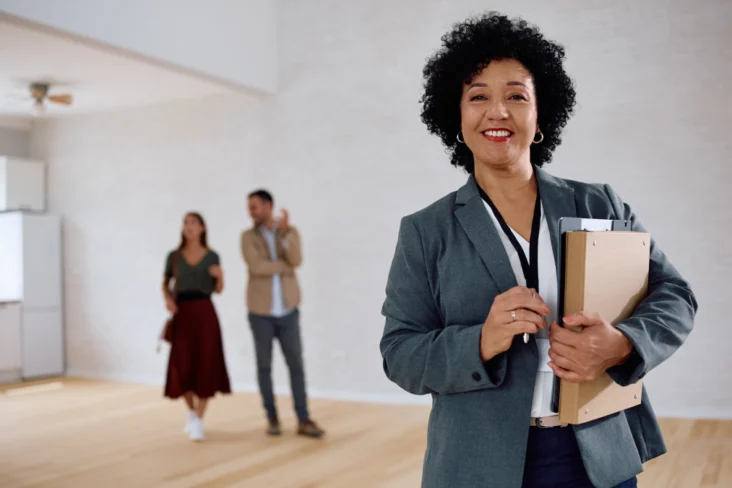 Agente imobiliária mostra uma habitação a dois clientes