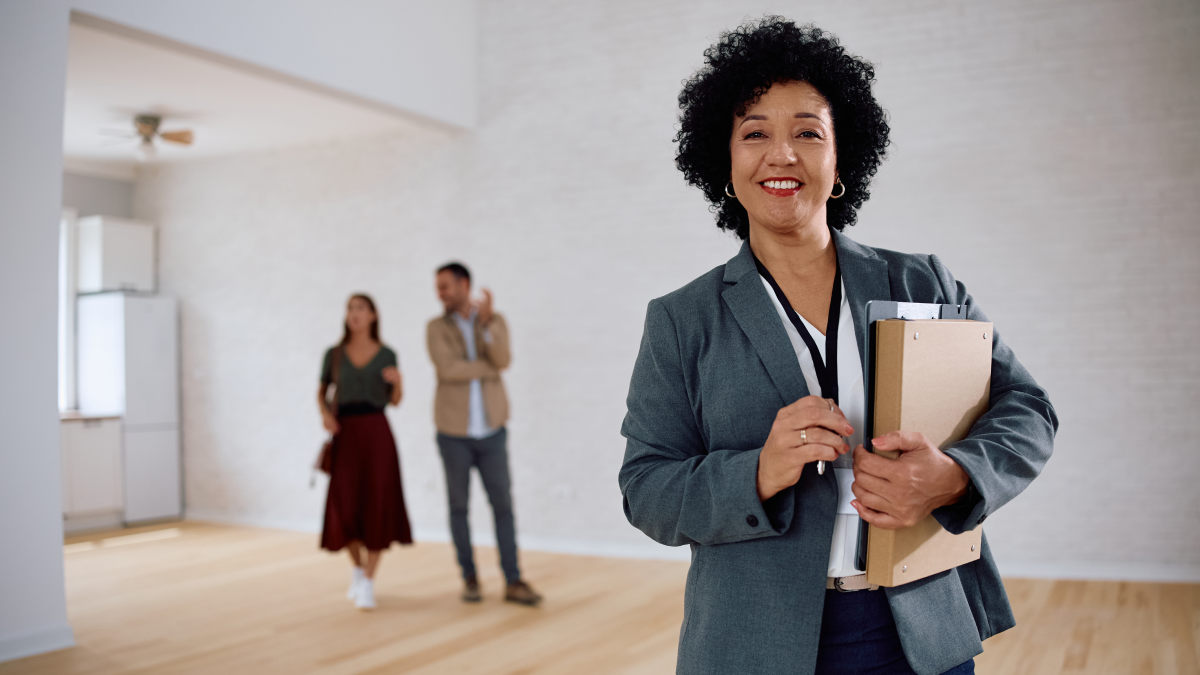 Licença de mediação imobiliária: Como obter e quais os requisitos Agente imobiliária mostra uma habitação a dois clientes