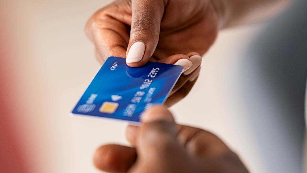 Pessoas a trocarem o cartão de crédito em mãos