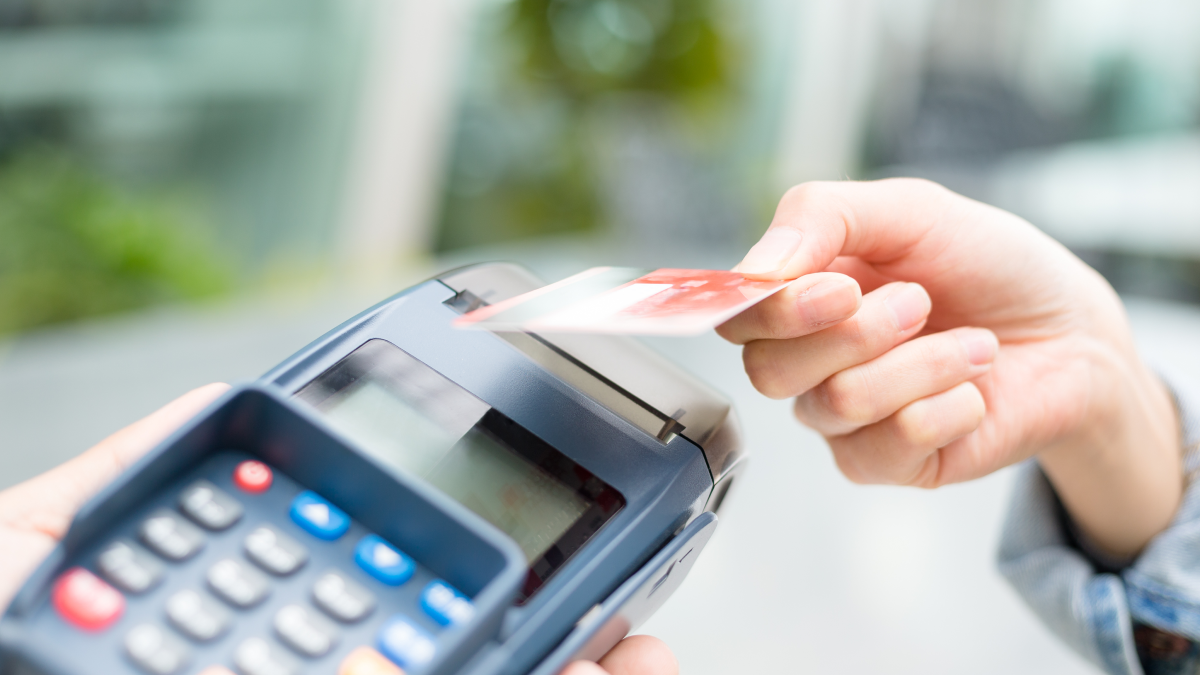 Como utilizar um cartão de crédito com responsabilidade Pessoa paga num terminal multibanco com um cartão de crédito contactless