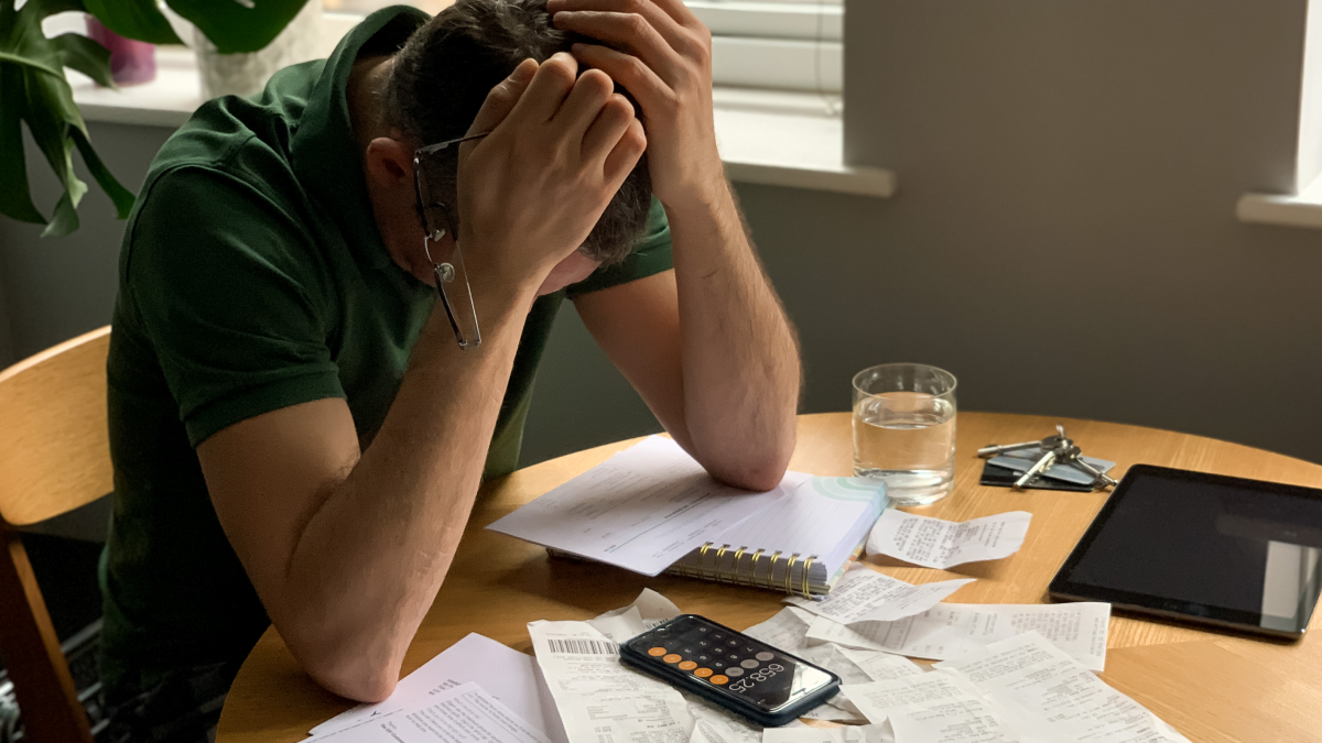 Homem frustrado com dívidas por pagar