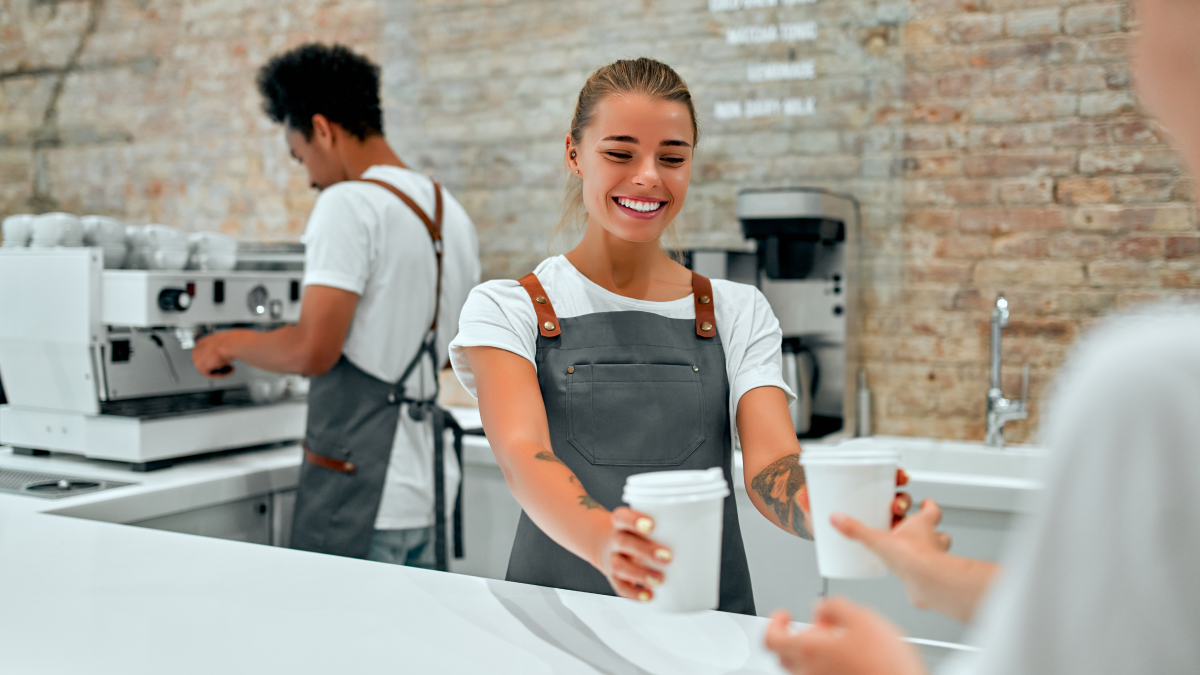 Jovens trabalham num bar a servir cafés