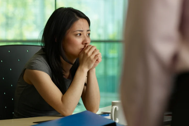 Mulher vítima de assédio laboral, desesperada com a situação