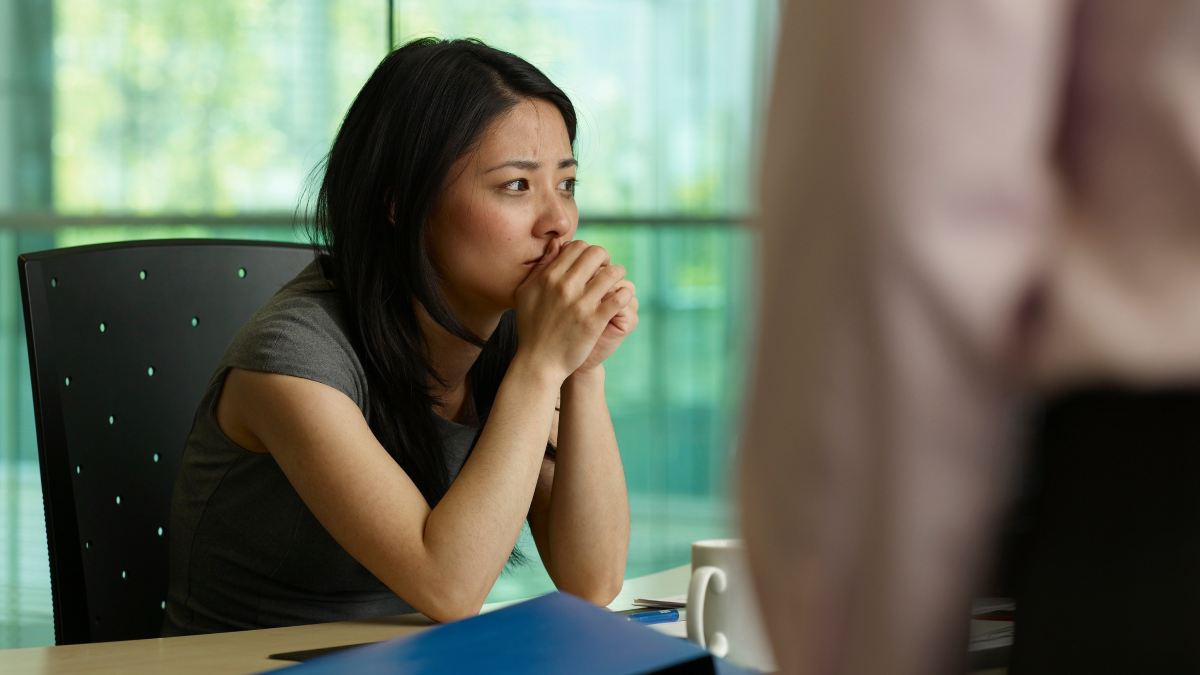 Mulher vítima de assédio laboral, desesperada com a situação