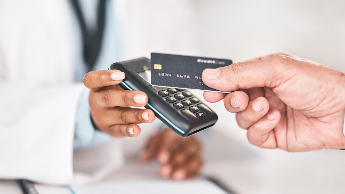 Como usar o cartão de crédito sem custos e sem perder benefícios Homem paga com cartão de crédito num terminal de multibanco