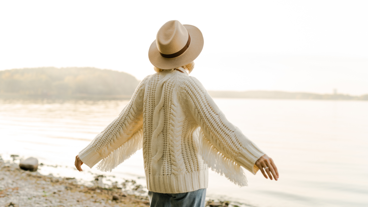 Mulher reformada aproveita bom tempo na praia para passear