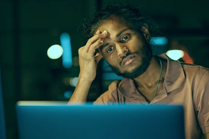 Trabalhador visivelmente exausto após trabalhar várias horas extra a pedido da empresa