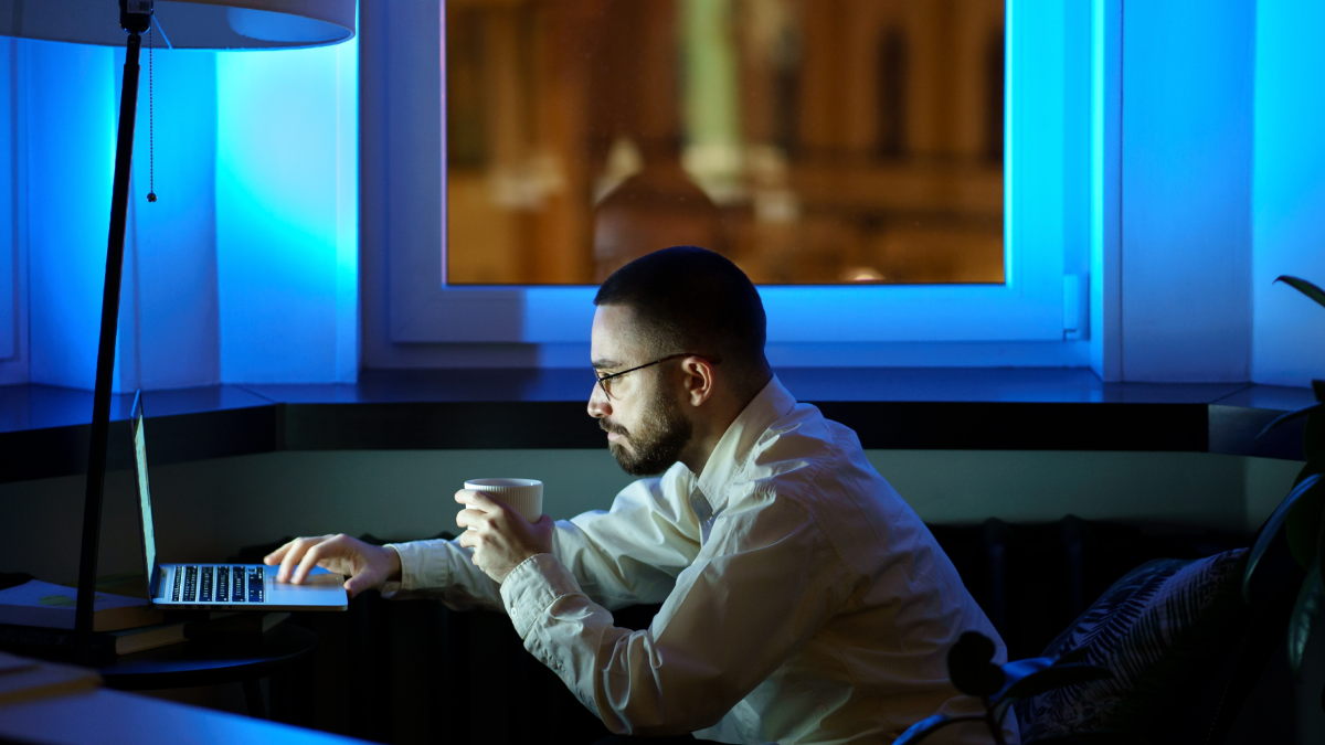 Homem a trabalhar com computador durante a noite, com isenção de horário