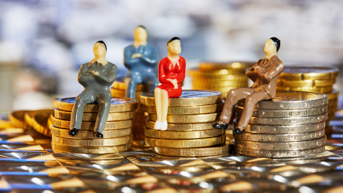 Bonecos sentados sobre moedas empilhadas