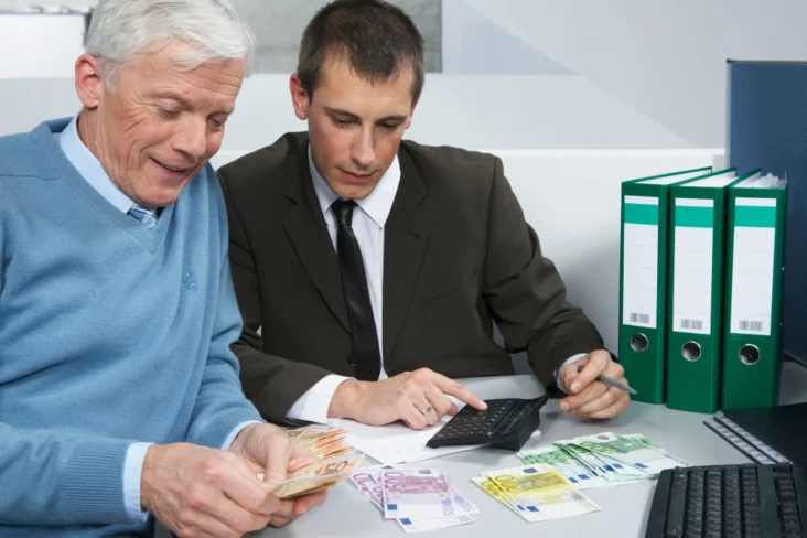 Homem mais velho explica investimentos a homem mais novo