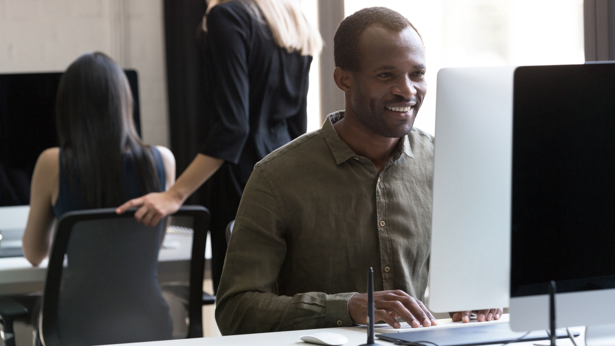 Homem sentado a trabalhar no seu computador no escritório