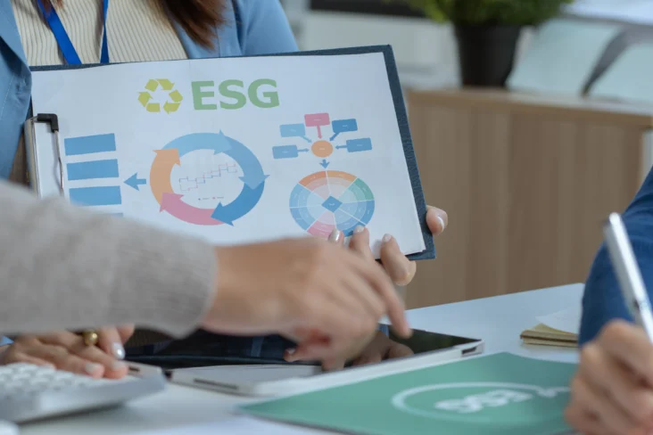 Mulher segura numa folha com a explicação do que são ESG