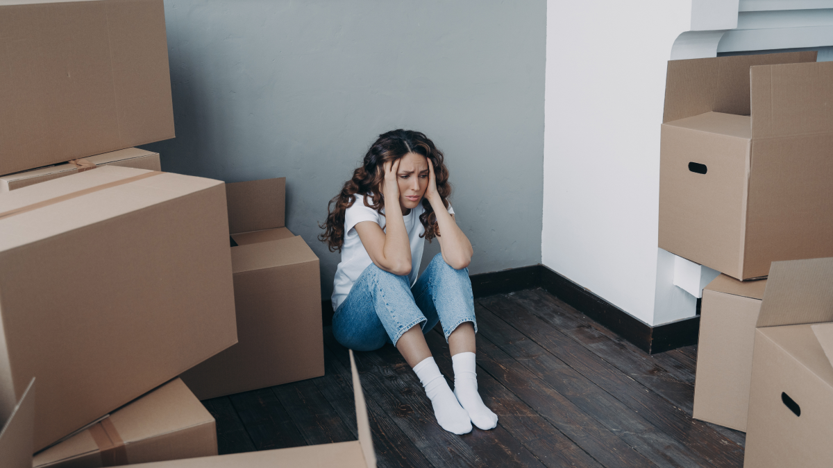 Direito de remição: O que é e quem pode exercer Mulher frustrada sentada no chão após mudanças de casa forçadas