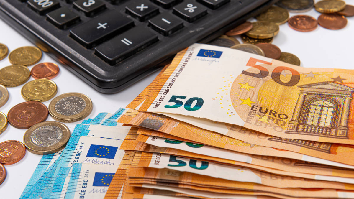 Notas e moedas de Euro, com uma calculadora